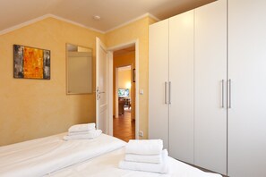 Quarto de hotel com cama, guarda-roupa e um quadro na parede.