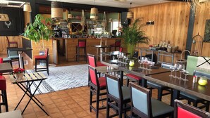 A restaurant with wooden walls, hanging wicker lamps, and red chairs. - Chalet in a private park in Saint Pierre D'oléron (Saint-Pierre-d'Oléron)