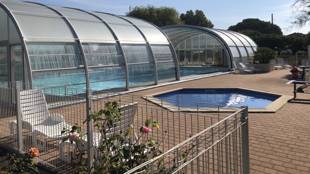 A covered swimming pool with lounge chairs and a greenhouse structure. - Chalet in a private park in Saint Pierre D'oléron (Saint-Pierre-d'Oléron)