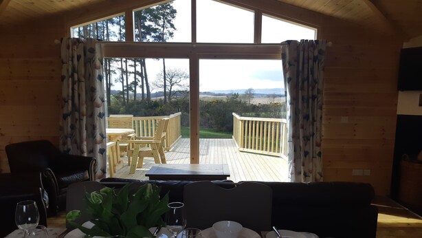 Comedor con una mesa para cuatro, vista del deck y decoración de madera.