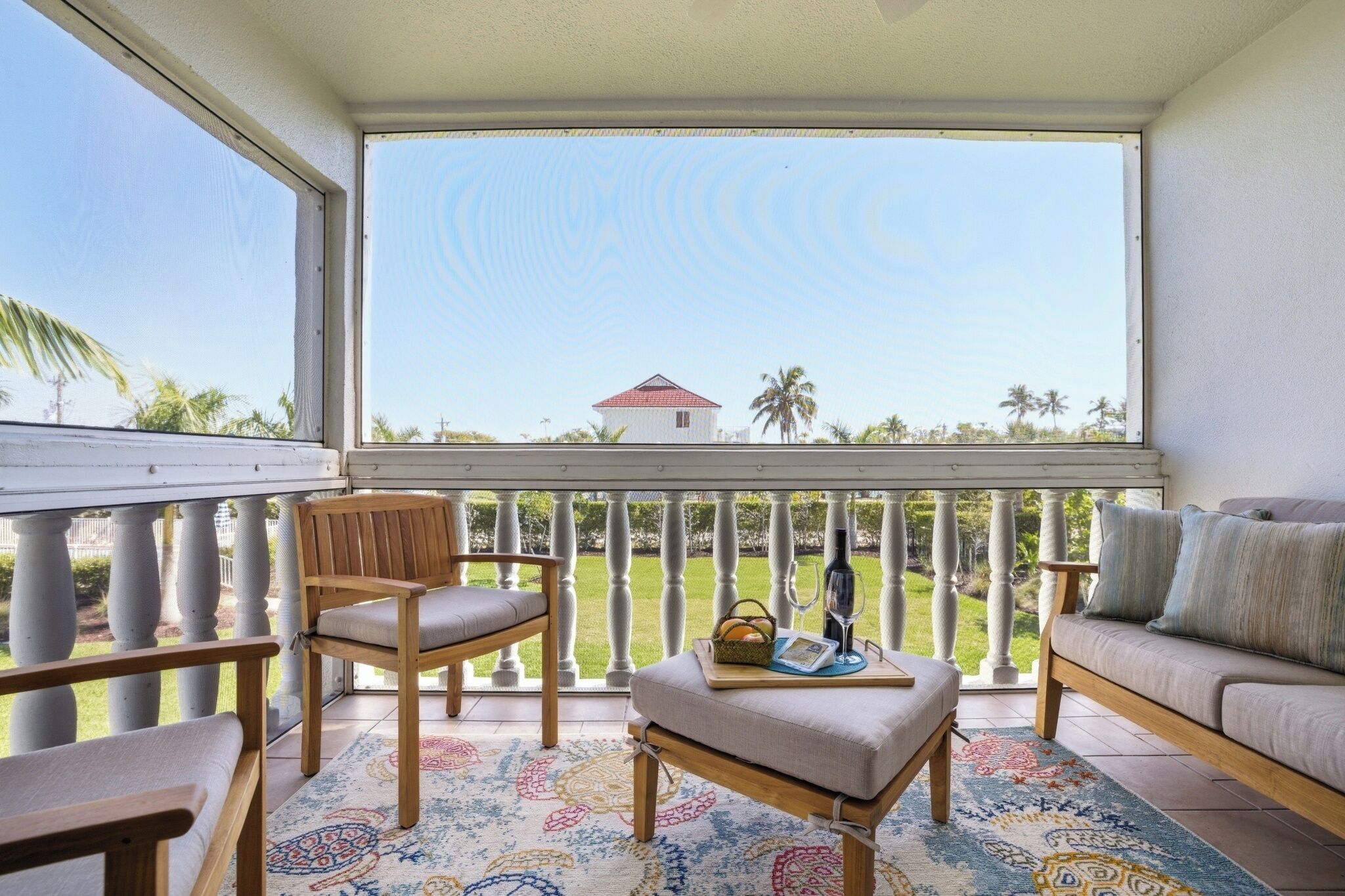 Ein Balkon mit Blick auf ein Haus und Palmen.