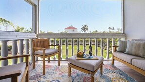Ein Balkon mit Blick auf ein Haus und Palmen.