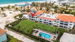 Ein Hotel direkt am Strand mit Pool, mehreren Balkonen und Blick aufs Meer.