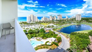 A high-rise hotel with a pool, a view of the ocean, and a cityscape in the background. - Gulf Views ~ Juliet Balcony ~ Resort Pool (Miramar Beach)