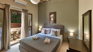 Ein Schlafzimmer mit einem großen Bett, Nachttischen mit Lampen, einem Gemälde an der Wand und Blick ins Freie durch ein Fenster.