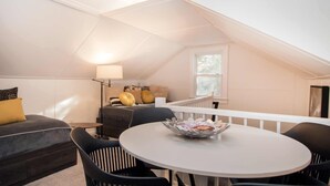 Une chambre mansardée accueillante, avec un lit, une petite table et une chaise.