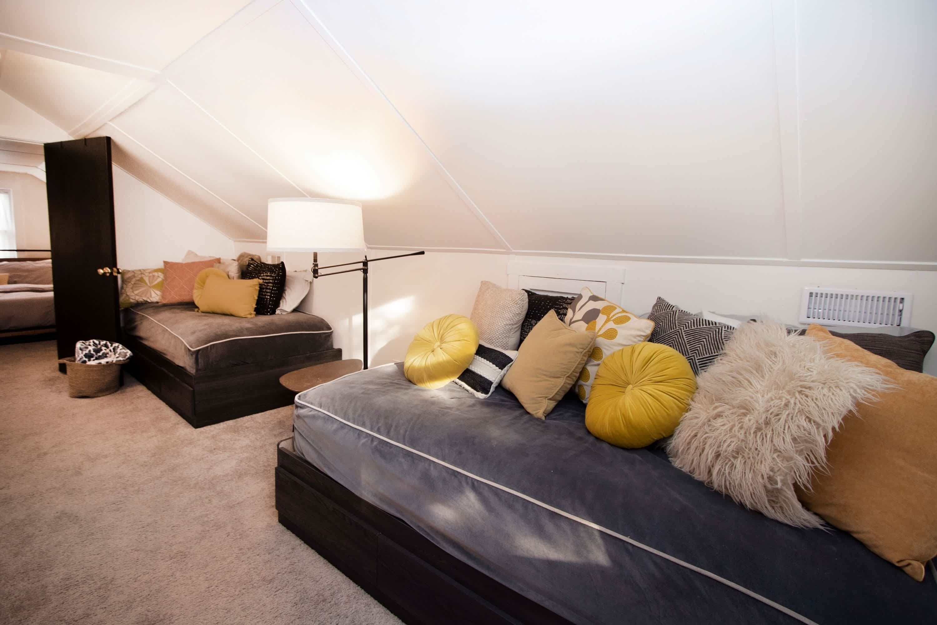 Een gezellig loft slaapkamer met een groot bed, een bank en een werkplek.