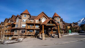 Un chalet à plusieurs étages, doté d’une entrée imposante, de balcons et offrant une vue sur les montagnes.