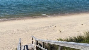 Una playa con un paseo de madera que lleva al agua.