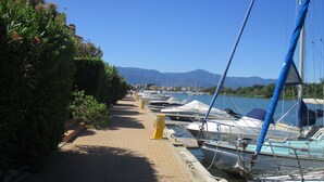 A marina with boats docked along a paved walkway. - SEAFRONT APARTMENT WITH SWIMMING POOL (Saint-Cyprien)