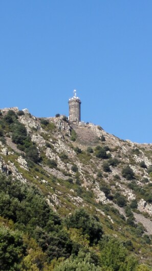Una torre de piedra sobre una colina rocosa con vegetación escasa.
