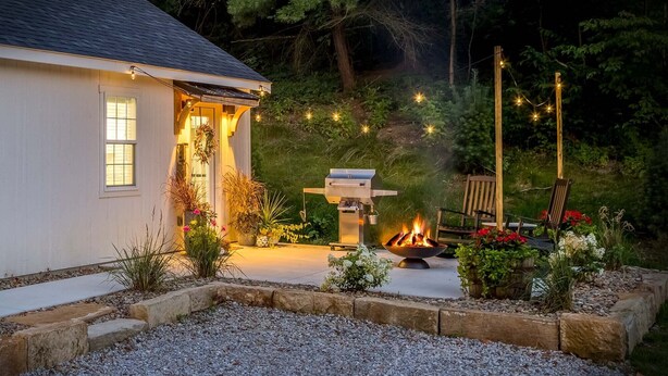 A house with a barbecue area, a fire pit, and string lights. - The Aspen . Trailside Lodging (Millersburg)