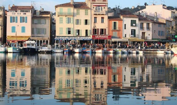 A waterfront with boats docked, buildings with shops, and a clear sky. - Apartment close to beaches in residence (Cassis)