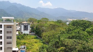 A multi-story hotel with balconies and a pool area, surrounded by lush greenery and mountains in the background. - Exclusive Apartment Arboleda 186 (San Pedro Sula)
