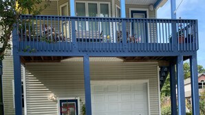 A two-story building with a balcony, a garage, and a bicycle parked in front.