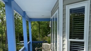 A covered porch with blue railings and wooden benches.