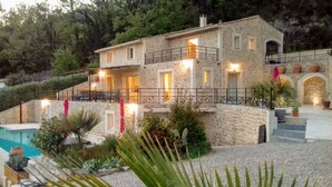 A stone house with a pool, surrounded by greenery and a staircase leading to the upper floors. - VERY NICE VILLA WITH HEATED POOL AND SUPERB VIEW ON BARGEMON AND HILLS (BARGEMON)