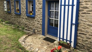 A stone building with a thatched roof, a blue door, and windows with blue frames. - Je Recharge mes "batteries" à Sainte Marine (Combrit)