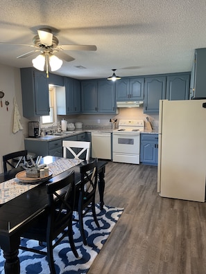 A kitchen with blue cabinets, a white refrigerator, a stove, and a ceiling fan. - Countryside paradise 6 miles to Stockton Lake! We now have high-speed internet! (Stockton)