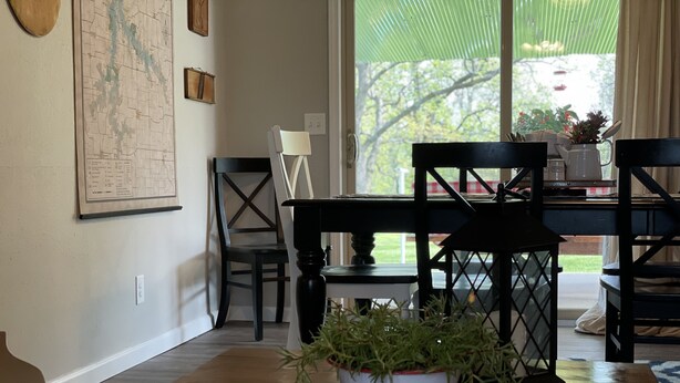 A dining area with a wooden table, chairs, and a potted plant. - Countryside paradise 6 miles to Stockton Lake! We now have high-speed internet! (Stockton)