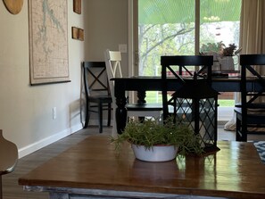 A dining area with a wooden table, chairs, and a potted plant.
