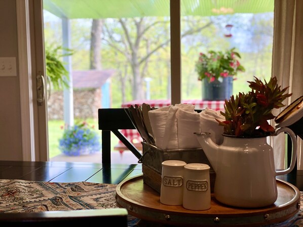 A table with a pitcher, salt and pepper shakers, and a potted plant.