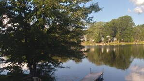 A lakeside dock with a wooden deck, a small boat, and a picnic table. - Bluegill lake -Lake front retreat (Harrison)