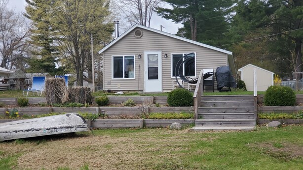 A single-story house with a front porch, a garage, and a small shed. - Bluegill lake -Lake front retreat (Harrison)