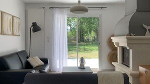 Una sala de estar moderna con un sofá oscuro, una mesita auxiliar, una lámpara y una chimenea.