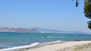 A beach with clear skies, calm waters, and distant mountains. - 1-bedroom Kos Olympia Apartment at Lambi Beach (Kos)