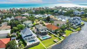 A residential area with houses, a swimming pool, and a body of water. - Siesta Del Sol- Lakefront, Destiny West, Private Pool, Tennis, Fitness! (Destin)