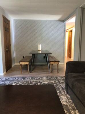 Relax in this inviting space with a central table, two chairs, and a comfortable sofa.