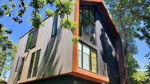 A modern multi-story building with large windows and a balcony. - This deluxe modern new 3-story home with central AC offers the best of Bozeman! (Bozeman)