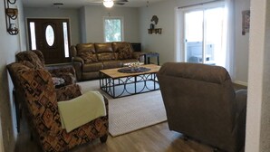 A living room with a brown leather sofa, patterned armchairs, a wooden coffee table, and a ceiling fan. - Black Hills MOJO, come and enjoy the beautiful Nemo area in the Northern Hills. (Nemo)