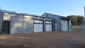 A building with three garage doors and a metal roof. - Black Hills MOJO, come and enjoy the beautiful Nemo area in the Northern Hills. (Nemo)