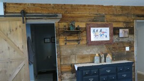 A rustic room with a wooden wall, a blue dresser, and a door leading to another room. - Black Hills MOJO, come and enjoy the beautiful Nemo area in the Northern Hills. (Nemo)