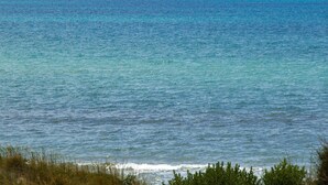 A view of the ocean with a distant boat on the horizon.