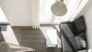 A modern room with a skylight, a white heater, and a black leather sofa. - Beautiful home in Löttorp with WiFi (Löttorp)