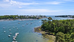 A coastal marina with numerous boats docked, surrounded by lush greenery and a clear sky. - 2 bedroom nice home in Pleuven (Pleuven)