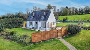 A house with a white exterior, a dark roof, and a wooden fence. - 2 bedroom nice home in Pleuven (Pleuven)