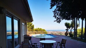 A patio with a pool, outdoor furniture, and a view of the sea. - Holiday flower villa with pool (Misterbianco)
