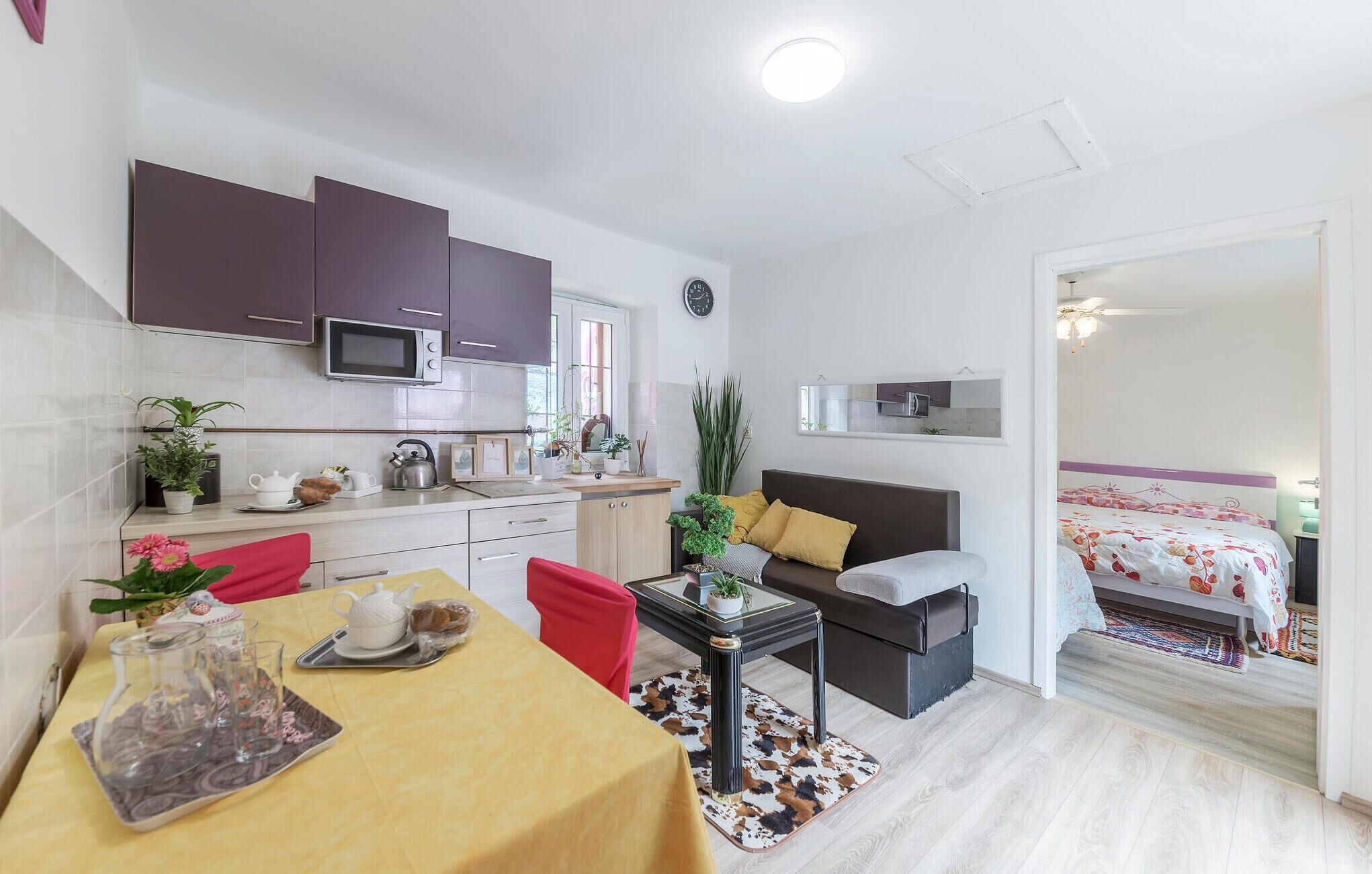 Un espacio habitable compacto con kitchenette, comedor y dormitorio.