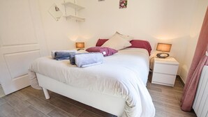 Een keurig opgemaakt slaapkamer met een bed, nachtkastjes en een nachtkastje.