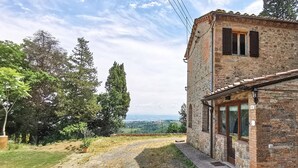 A rustic stone building with a small porch, surrounded by trees and a view of the countryside. - 6 bedroom nice home in Montaione (Montaione)