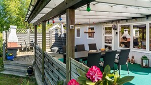 A covered patio area with outdoor seating, a barbecue grill, and a wooden deck. - 3 bedroom lovely home in Gedser (Gedser)