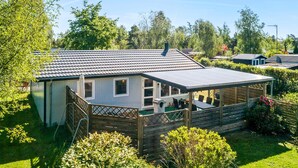A single-story house with a covered patio, a fenced yard, and a small garden. - 3 bedroom lovely home in Gedser (Gedser)