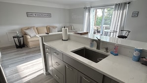 Una cocina moderna con una isla grande, electrodomésticos integrados y un comedor con vistas al exterior.