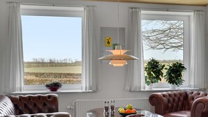 A room with two windows, a table with fruit, a potted plant, and a hanging light fixture. - 3 bedroom beautiful apartment in Kibæk (Kibæk)