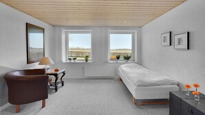 A bedroom with a wooden ceiling, two windows, a bed, a chair, a table, and a radiator. - 3 bedroom beautiful apartment in Kibæk (Kibæk)