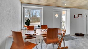 A modern dining area with a wooden table, six chairs, and a view of the outdoors through large windows. - 3 bedroom beautiful apartment in Kibæk (Kibæk)